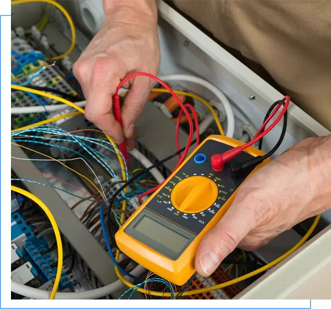 A person is working on wires with a multimeter.