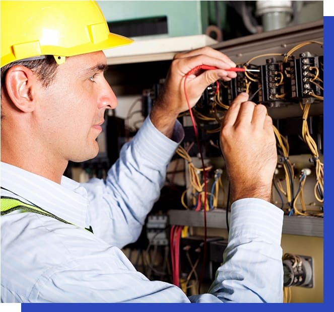 A man in yellow hard hat working on electrical equipment.