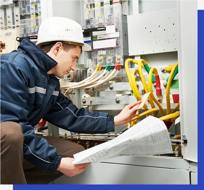 A man working on electrical equipment in an industrial setting.